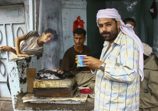 Yemeni man eating bbq in a street restaurant, Ibb Governorate, Jibla, Yemen