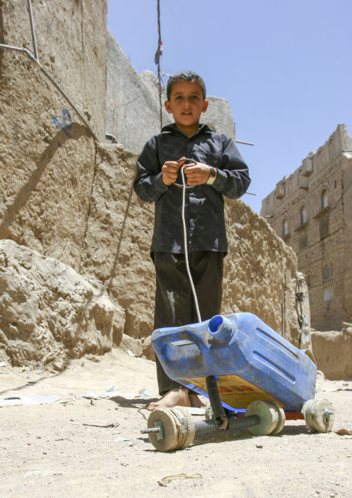Yemeni boy playing with a jerrican, Al Bayda Governorate, Rada, Yemen
