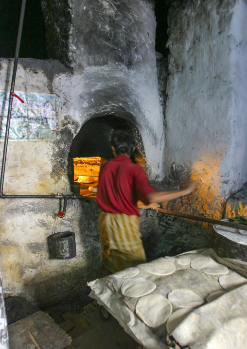 Baker working in front of his oven, Janad Region, Taiz, Yemen