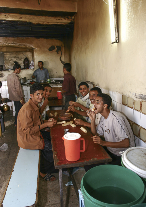 Yemeni young men eating in a restaurant, Al Hudaydah Governorate, Hodeidah, Yemen