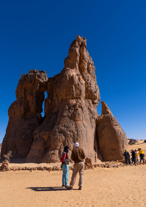 Tourists visiting la vache qui pleure rock carving, North Africa, Erg Admer, Algeria