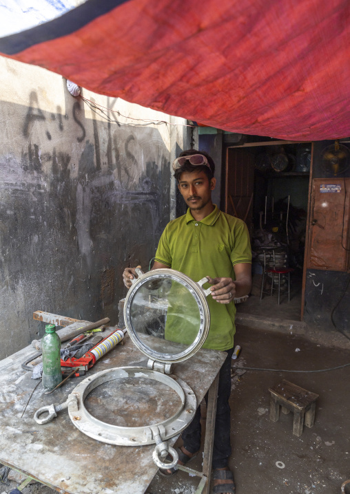 Bangladeshi worker with a porthole at Dhaka Shipyard, Dhaka Division, Keraniganj, Bangladesh