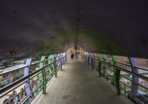Bangladeshi man on a pedestrians walk on bridge over a road, Dhaka Division, Dhaka, Bangladesh