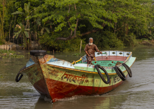 Old man on a local boat on a river, Barisal Division, Banaripara, Bangladesh