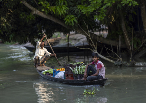 Man with his son carrying vegetables on a boat, Barisal Division, Banaripara, Bangladesh