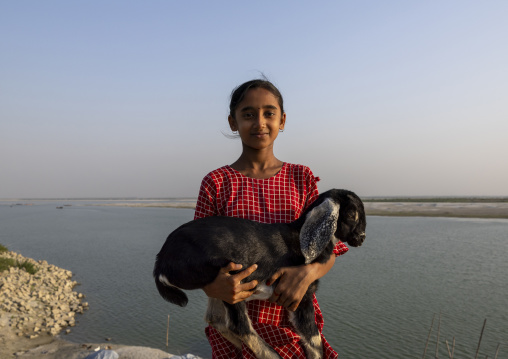 Portrait of smiling girl carrying a baby sheep, Rajshahi Division, Rajshahi, Bangladesh