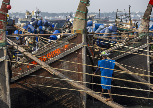 A bangladeshi porter carries a load from a trawler at the morning fish market, Chittagong Division, Chittagong, Bangladesh