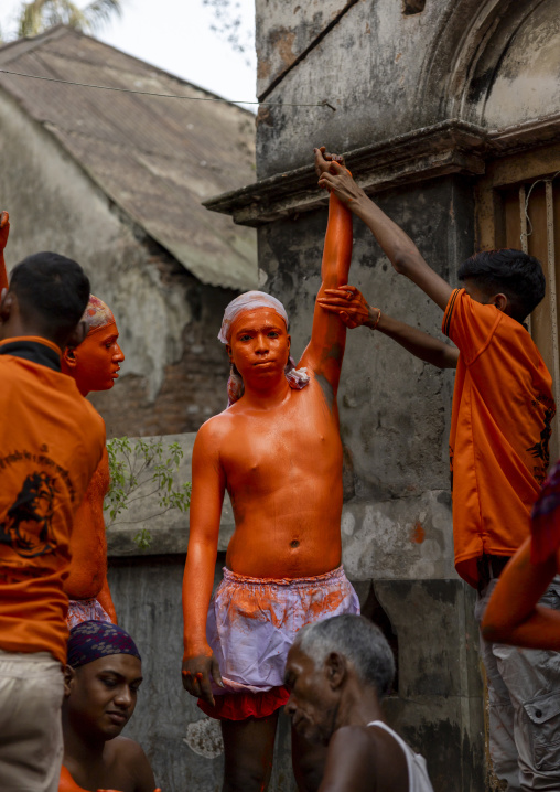Make up of a Hindu devotee covered with orange color at Lal Kach festival, Dhaka Division, Munshiganj, Bangladesh
