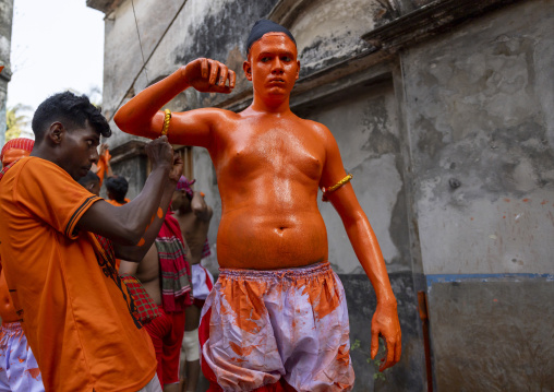 Make up of a Hindu devotee covered with orange color at Lal Kach festival, Dhaka Division, Munshiganj, Bangladesh