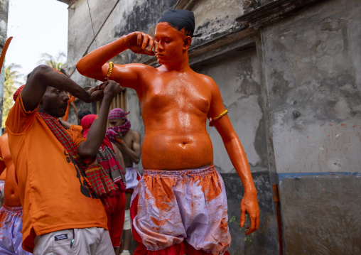 Make up of a Hindu devotee covered with orange color at Lal Kach festival, Dhaka Division, Munshiganj, Bangladesh