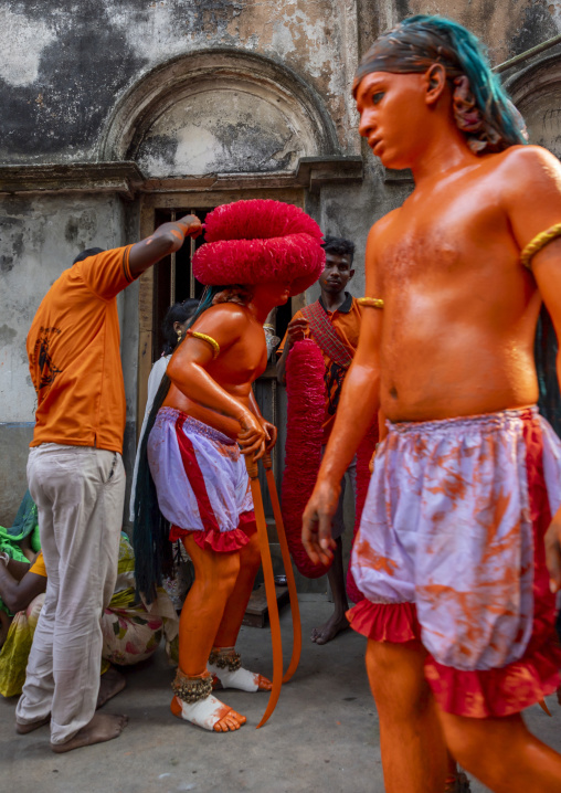 Dressing of a Hindu devotee covered with orange color at Lal Kach festival, Dhaka Division, Munshiganj, Bangladesh