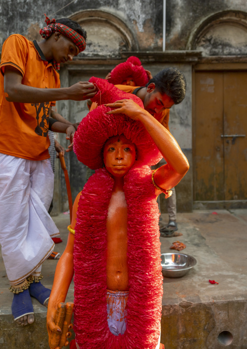 Dressing of a Hindu devotee covered with orange color at Lal Kach festival, Dhaka Division, Munshiganj, Bangladesh