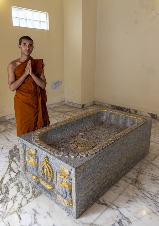 Monk praying in front of a grave in Shalban Buddhist Monastery, Chittagong Division, Comilla, Bangladesh