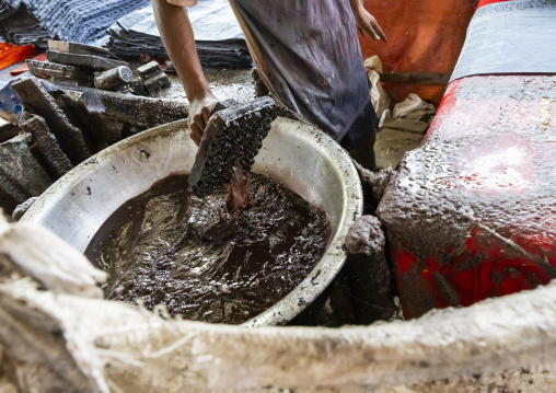 Bangladeshi man stamping wax on a cloth in a batik factory, Chittagong Division, Comilla, Bangladesh