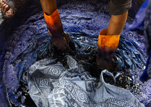 Bangladeshi man dyeing fabrics in blue in a batik factory, Chittagong Division, Comilla, Bangladesh