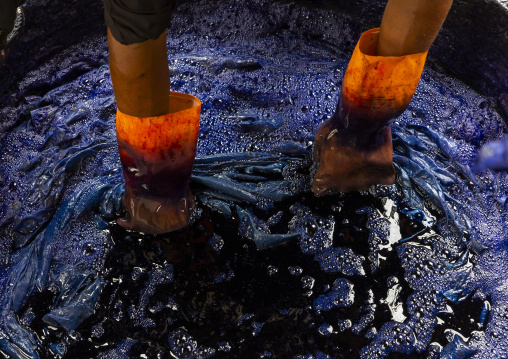 Bangladeshi man dyeing fabrics in blue in a batik factory, Chittagong Division, Comilla, Bangladesh