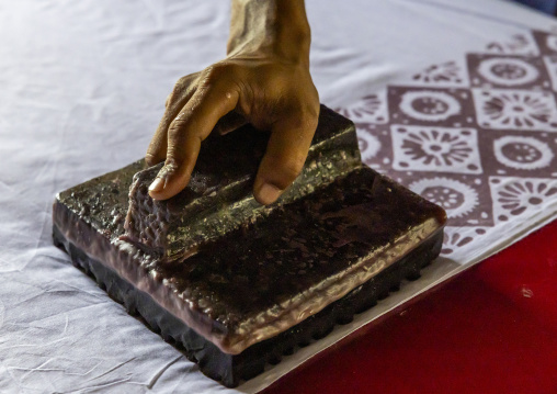 Bangladeshi man stamping wax on a cloth in a batik factory, Chittagong Division, Comilla, Bangladesh