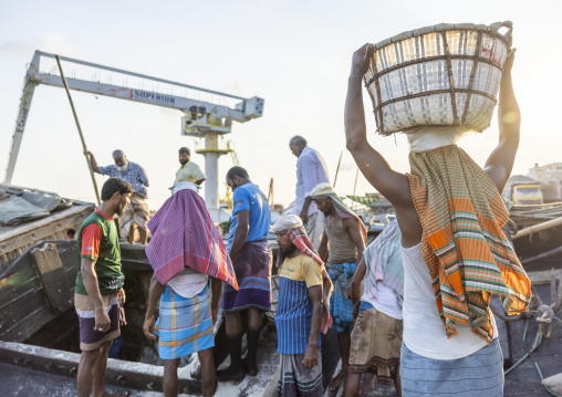 Bangladeshi men weighing baskets with salt at a factory, Chittagong Division, Chittagong, Bangladesh