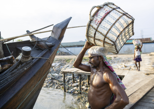 Bangladeshi man weighing basket with salt at a factory, Chittagong Division, Chittagong, Bangladesh