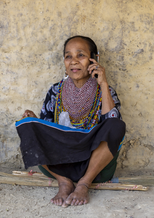 Tripura woman with necklaces and earrings calling on mobile phone, Chittagong Division, Rowangchhari, Bangladesh
