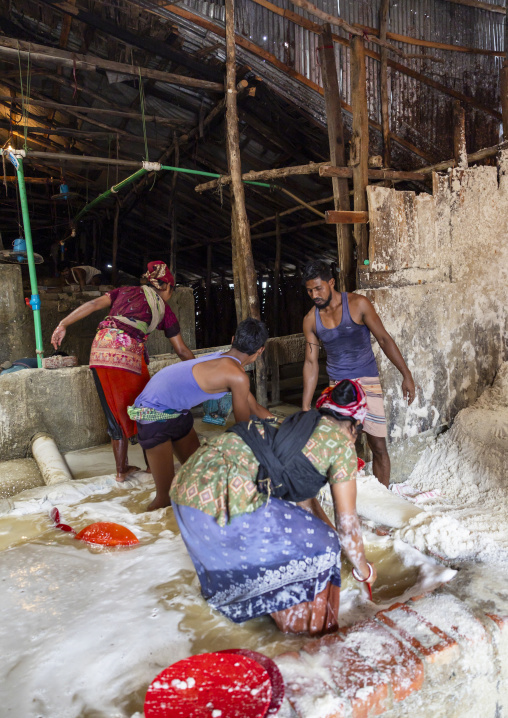 Bangladeshi workers washing salt in water in a factory, Chittagong Division, Chittagong, Bangladesh