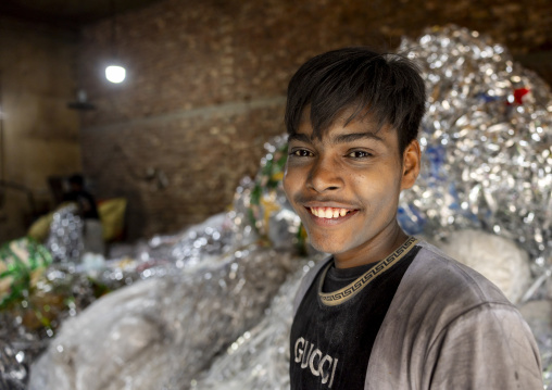 Bangladeshi teenage boy dismantling plastic bags for recycling, Dhaka Division, Dhaka, Bangladesh