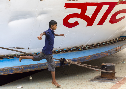 Boy jumping from an anchored ferry vessels at the dockyard, Dhaka Division, Dhaka, Bangladesh