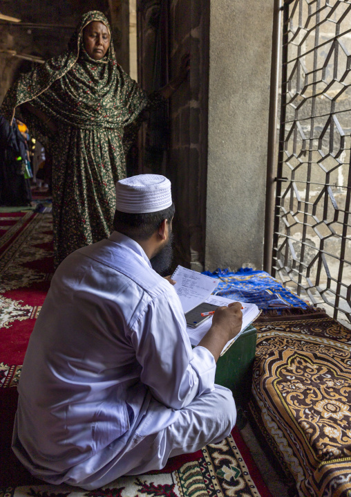 Bangladeshi imam writing inside Kusumba Mosque, Rajshahi Division, Kusumba, Bangladesh