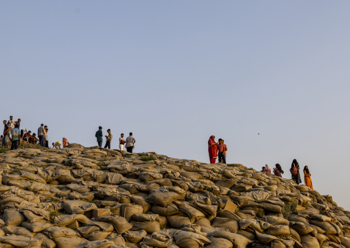 People walking on bags filled with sand to prevent from erosion, Rajshahi Division, Rajshahi, Bangladesh