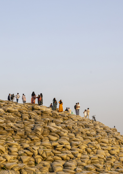 People walking on bags filled with sand to prevent from erosion, Rajshahi Division, Rajshahi, Bangladesh