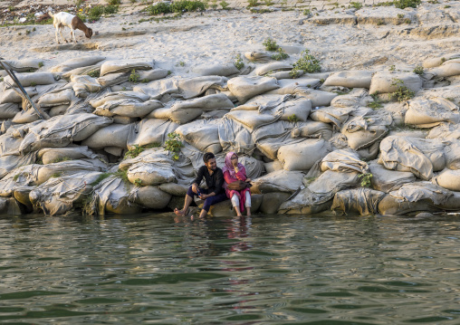 Bangladeshi couple relaxing on the riberbank, Rajshahi Division, Rajshahi, Bangladesh