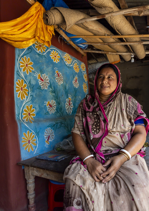 Bangladeshi woman in front of a traditional wall painting in a house, Rajshahi Division, Tikoil, Bangladesh
