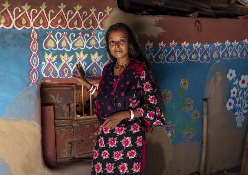Bangladeshi teenage girl in front of a traditional wall painting in a house, Rajshahi Division, Tikoil, Bangladesh