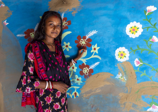 Bangladeshi teenage girl in front of a traditional wall painting in a house, Rajshahi Division, Tikoil, Bangladesh