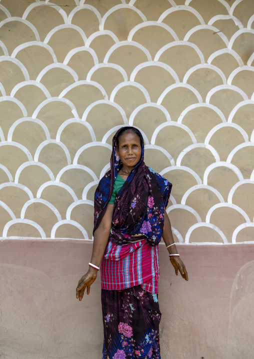 Bangladeshi woman in front of a traditional wall painting on a house, Rajshahi Division, Tikoil, Bangladesh