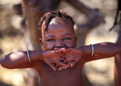 MuHimba girl yawning behin her hands, Cunene province, Oncocua, Angola