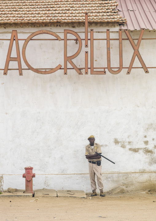Policeman in front of an old Acrilux store, Benguela Province, Benguela, Angola