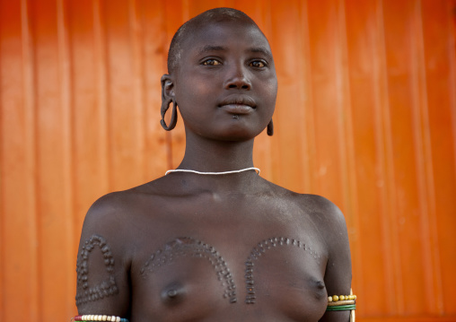 Mursi tribe topless shaved head woman, Omo valley, Kibish, Ethiopia