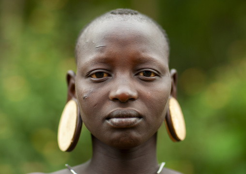 Mursi tribe woman with clay plate in ears, Ari zone, Jinka, Ethiopia