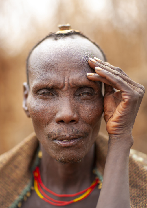 Portrait of a Dassanech man with hand on face, Omo valley, Omorate, Ethiopia