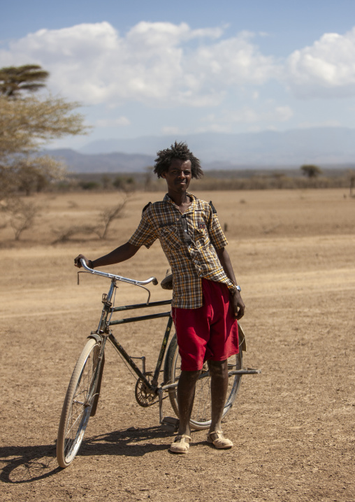 Portrait of a Karrayyu tribe man with his bike, Oromia, Metehara, Ethiopia