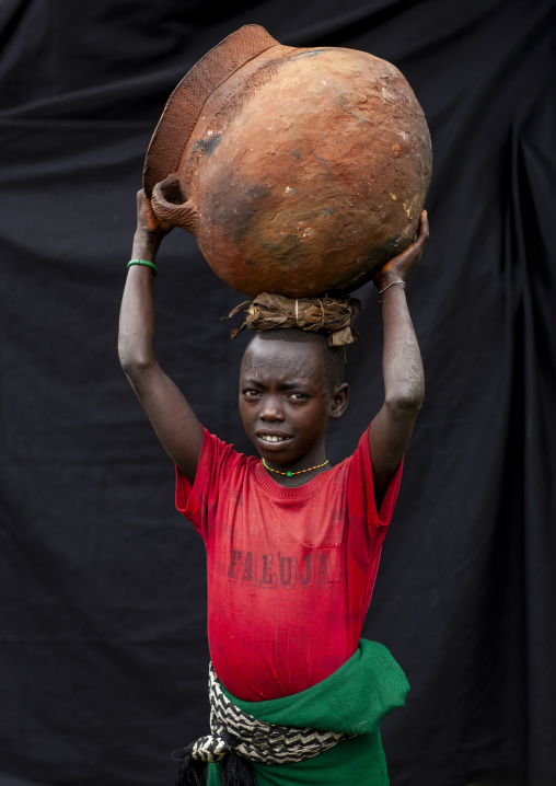Menit boy carrying a jar on his head, Omo valley, Tum, Ethiopia