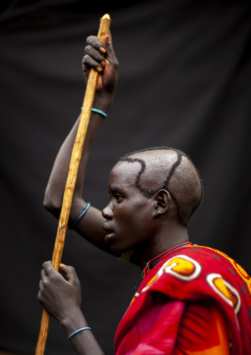 Menit young man holding a stick, Tum market, Omo valley, Tum, Ethiopia
