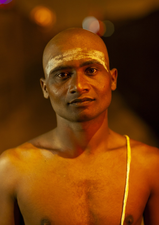 Young man becoming a naga sadhu duringMaha kumbh mela, Uttar Pradesh, Allahabad, India