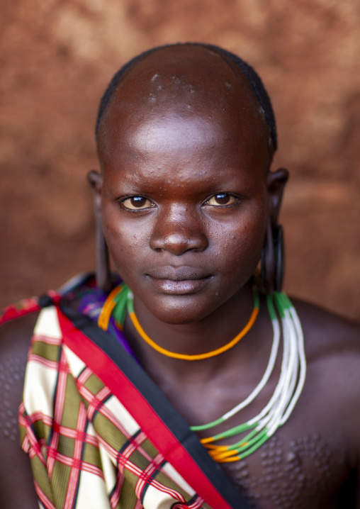 Suri tribe teenage girl with enlarged earlobe, Kibish, Omo valley, Ethiopia