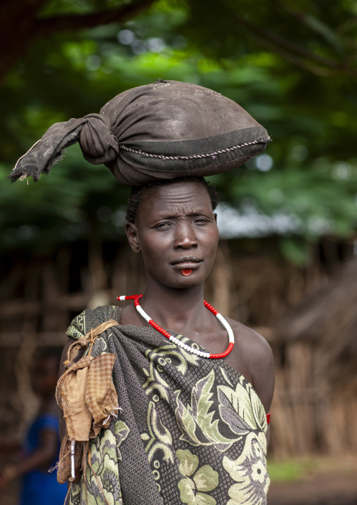 Portrait of a Bodi tribe woman carrying a bag on her head, Hana Mursi, Omo valley, Ethiopia
