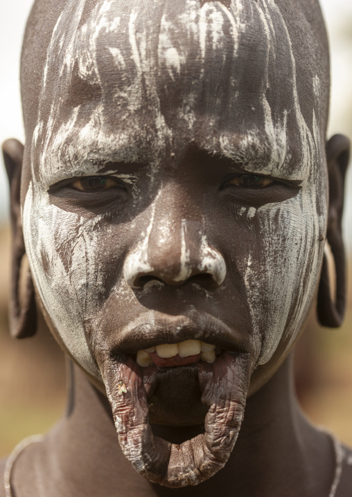 Mursi tribe woman with enlarged lip and ears, Mago national park, Omo valley, Ethiopia