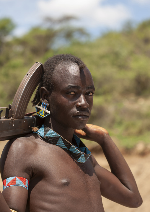 Portrait of a banna tribe warrior with kalashnikov, Omo valley, Key Afer, Ethiopia