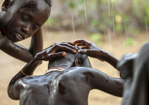 Children from Karo tribe having a shower under the rain, Korcho, Omo valley, Ethiopia
