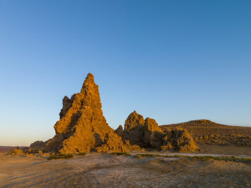 A tall limestone chimney rock formation stands beneath a clear blue sky, Afar depression, Lake Abbe, Djibouti